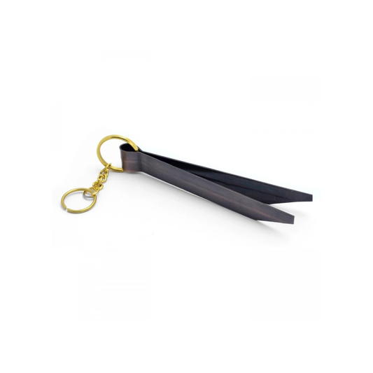 Brass tongs with metal keychain at one end for hanging. Black in colour.