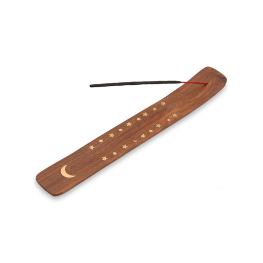 A wooden incense holder with an engraved moon and stars design, featuring a single incense stick resting across the top, set against a plain white background.